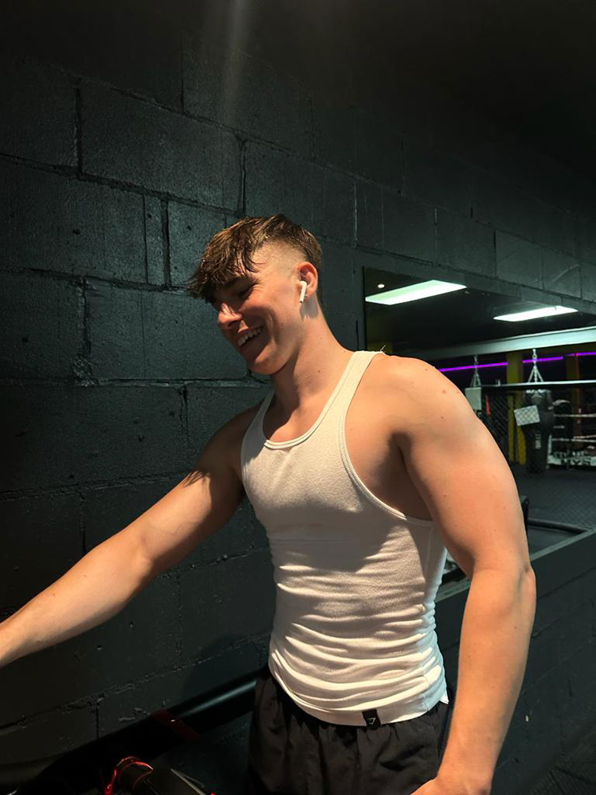 The coach is smiling in a gym.